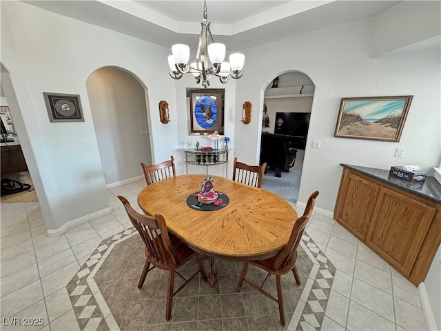 3451 Sagebrush Ave, Pahrump, NV 89048 - dining area featuring arched walkways, light tile patterned floors, a chandelier, and baseboards
