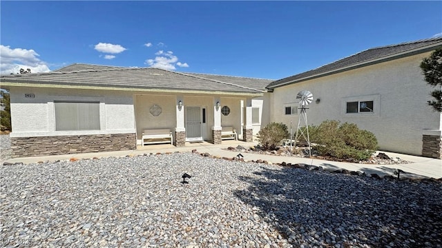 3451 Sagebrush Ave, Pahrump, NV 89048 - view of front of house featuring stucco siding, a porch, and stone siding