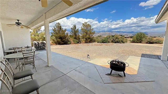3451 Sagebrush Ave, Pahrump, NV 89048 - view of patio / terrace with ceiling fan, a fire pit, and a mountain view
