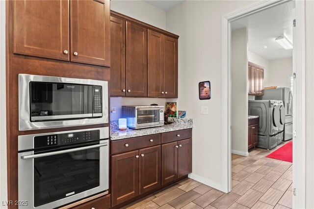 6980 W Meranto Ave, Las Vegas, NV 89178 - kitchen featuring oven, built in microwave, independent washer and dryer, wood finish floors, and light stone countertops
