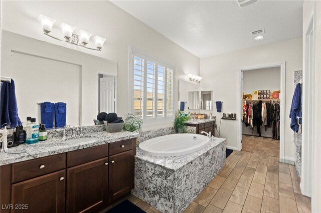 6980 W Meranto Ave, Las Vegas, NV 89178 - full bathroom with wood tiled floors, two vanities, a bath, and a walk in closet