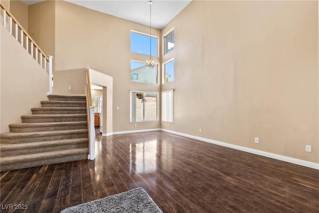 5 Spur Cross Cir, Henderson, NV 89012 - unfurnished living room featuring stairway, wood finished floors, a chandelier, and baseboards
