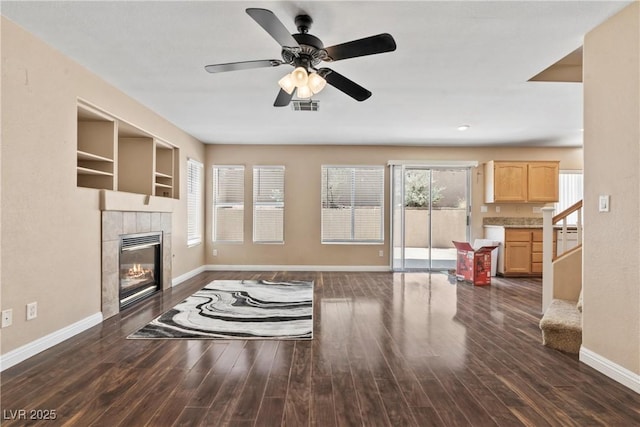 5 Spur Cross Cir, Henderson, NV 89012 - unfurnished living room with baseboards, a tile fireplace, dark wood finished floors, and a ceiling fan