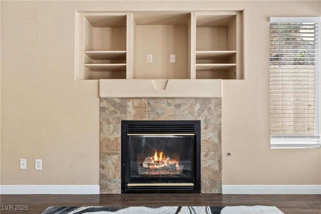 5 Spur Cross Cir, Henderson, NV 89012 - detailed view of built in shelves, baseboards, a tile fireplace, and wood finished floors