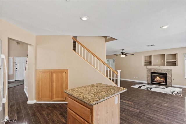 5 Spur Cross Cir, Henderson, NV 89012 - kitchen with baseboards, dark wood-type flooring, ceiling fan, light stone countertops, and a high end fireplace