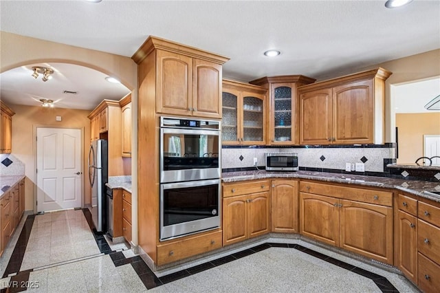 9111 W Stephen Ave, Las Vegas, NV 89149 - kitchen featuring inlaid floor details, stainless steel appliances, arched walkways, recessed lighting, and backsplash
