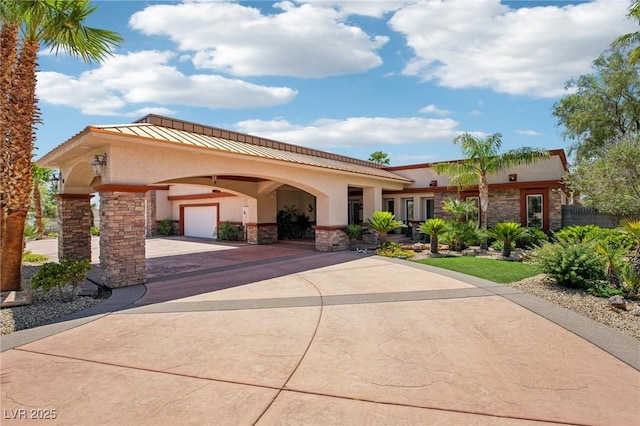 9111 W Stephen Ave, Las Vegas, NV 89149 - view of front of home featuring stone siding, stucco siding, concrete driveway, a standing seam roof, and a garage