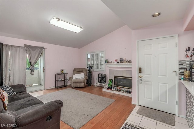 2725 S Nellis Blvd Unit 2168, Las Vegas, NV 89121 - living room featuring vaulted ceiling, a tile fireplace, and light wood-style flooring
