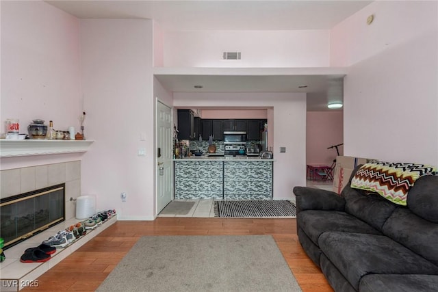 2725 S Nellis Blvd Unit 2168, Las Vegas, NV 89121 - living area featuring light wood-style floors, a tiled fireplace, and baseboards