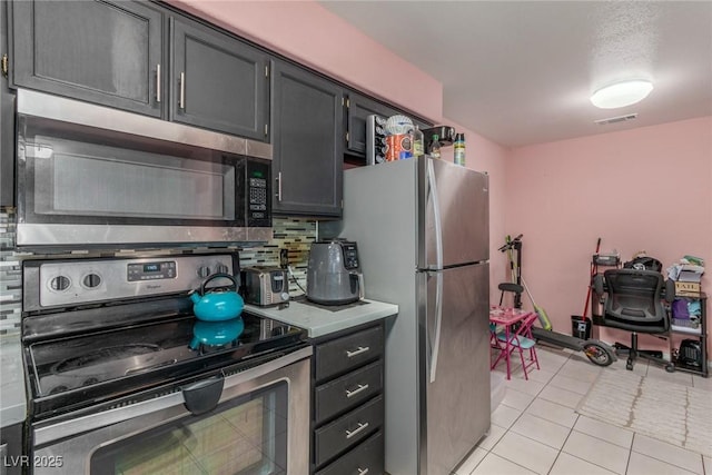 2725 S Nellis Blvd Unit 2168, Las Vegas, NV 89121 - kitchen featuring appliances with stainless steel finishes, backsplash, light countertops, and light tile patterned floors