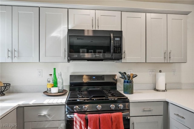 3880 Enchanted Sky St, Las Vegas, NV 89129 - kitchen featuring stainless steel microwave, black gas range, gray cabinetry, and light countertops
