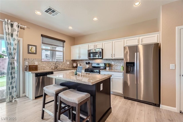 9853 Bangalore Ct, Las Vegas, NV 89148 - kitchen featuring stainless steel appliances, a sink, a center island, white cabinetry, and recessed lighting