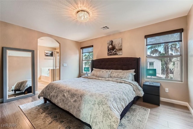 9853 Bangalore Ct, Las Vegas, NV 89148 - bedroom featuring arched walkways, light wood-style flooring, and baseboards