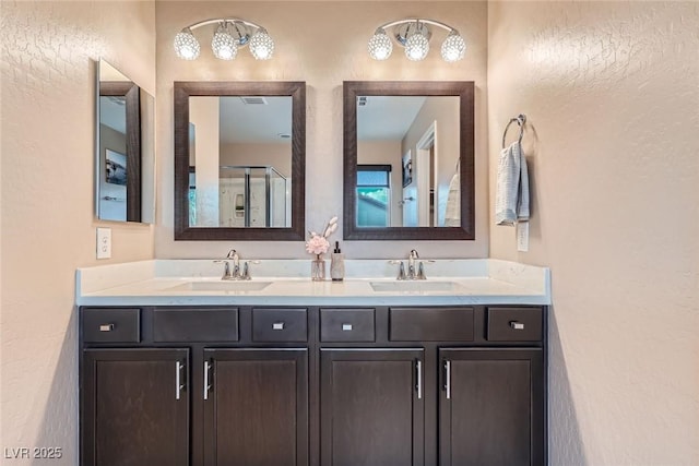 9853 Bangalore Ct, Las Vegas, NV 89148 - full bathroom featuring double vanity, a textured wall, and an enclosed shower