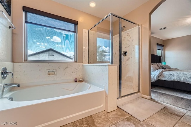 9853 Bangalore Ct, Las Vegas, NV 89148 - bathroom with a garden tub, a stall shower, ensuite bath, and tile patterned floors