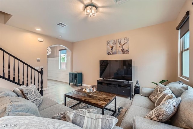 9853 Bangalore Ct, Las Vegas, NV 89148 - living area featuring arched walkways, wood finished floors, stairs, baseboards, and recessed lighting