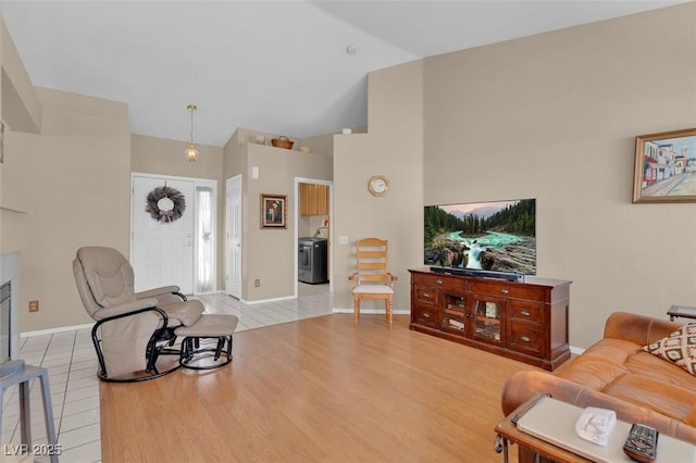 4628 Standing Bluff Way, Las Vegas, NV 89130 - living area with light tile patterned flooring, high vaulted ceiling, baseboards, and washer / clothes dryer