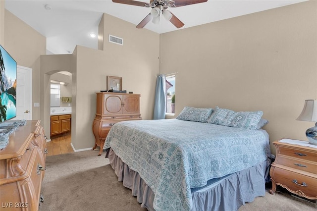4628 Standing Bluff Way, Las Vegas, NV 89130 - bedroom with light colored carpet, arched walkways, connected bathroom, a ceiling fan, and baseboards