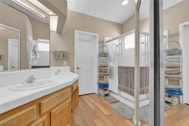 4628 Standing Bluff Way, Las Vegas, NV 89130 - bathroom featuring wood finished floors, double vanity, and a stall shower