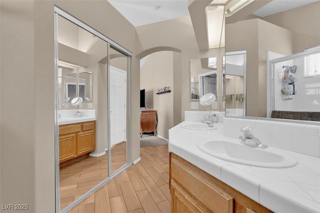 4628 Standing Bluff Way, Las Vegas, NV 89130 - full bathroom with double vanity, wood finish floors, and a shower with door