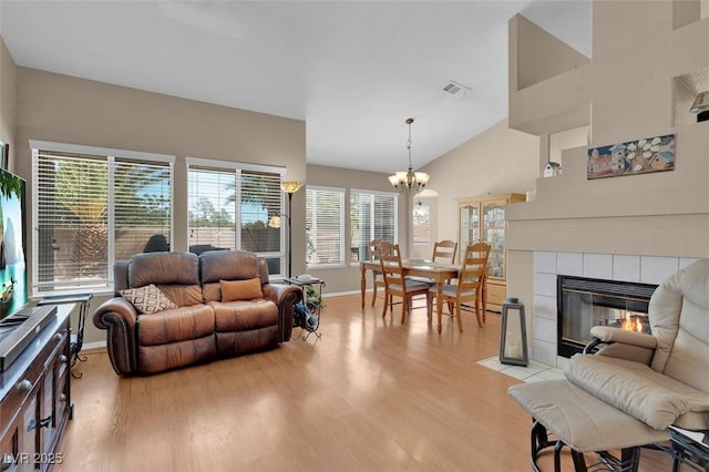 4628 Standing Bluff Way, Las Vegas, NV 89130 - living area with light wood-style flooring, plenty of natural light, a fireplace, baseboards, and high vaulted ceiling