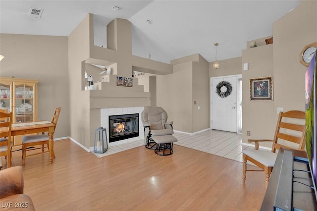 4628 Standing Bluff Way, Las Vegas, NV 89130 - living room featuring high vaulted ceiling, baseboards, a tile fireplace, and wood finished floors