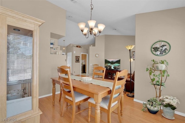 4628 Standing Bluff Way, Las Vegas, NV 89130 - dining area featuring a chandelier, light wood finished floors, baseboards, and vaulted ceiling