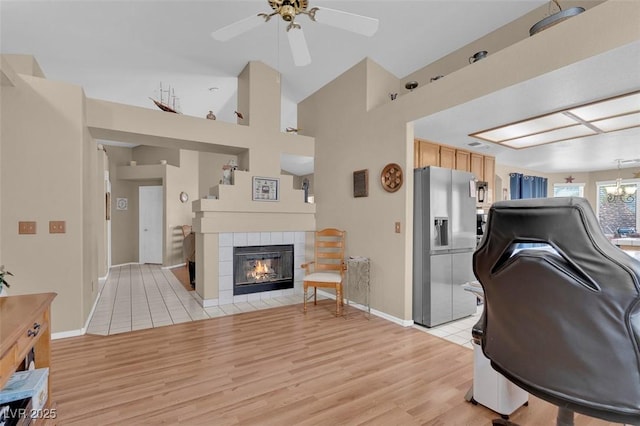 4628 Standing Bluff Way, Las Vegas, NV 89130 - living area with a ceiling fan, light wood finished floors, a fireplace, baseboards, and high vaulted ceiling