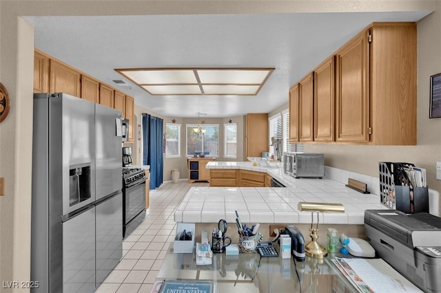 4628 Standing Bluff Way, Las Vegas, NV 89130 - kitchen featuring stainless steel appliances, tile counters, a peninsula, light tile patterned floors, and hanging light fixtures