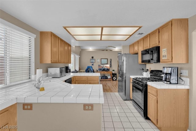 4628 Standing Bluff Way, Las Vegas, NV 89130 - kitchen with black appliances, tile countertops, a peninsula, and a sink