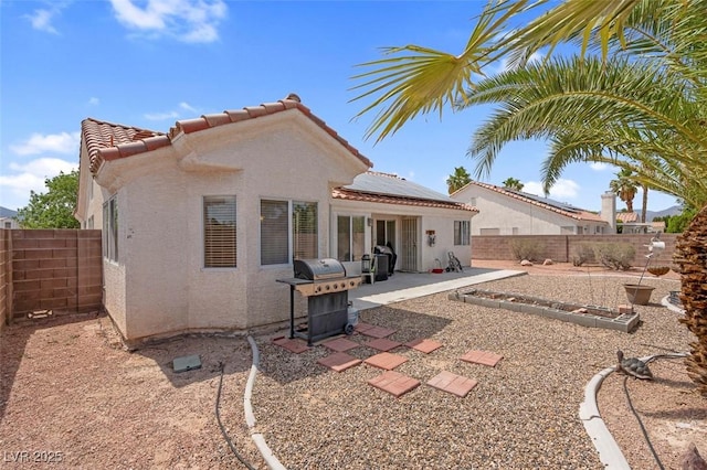 4628 Standing Bluff Way, Las Vegas, NV 89130 - back of property featuring solar panels, a tile roof, a fenced backyard, a patio, and stucco siding