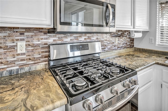 7886 Palace Monaco Ave, Las Vegas, NV 89117 - kitchen with appliances with stainless steel finishes, white cabinets, backsplash, and stone countertops