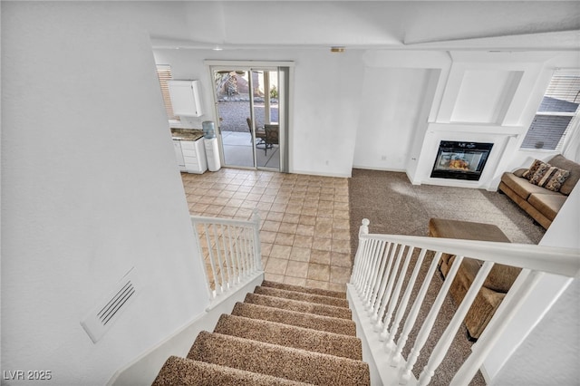 7886 Palace Monaco Ave, Las Vegas, NV 89117 - stairway with a glass covered fireplace and baseboards