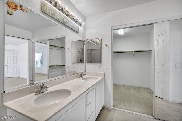7886 Palace Monaco Ave, Las Vegas, NV 89117 - bathroom featuring double vanity, baseboards, and a walk in closet