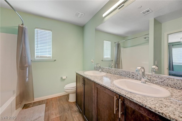 6940 Crescent Gold St, North Las Vegas, NV 89086 - full bath with healthy amount of natural light, wood finished floors, double vanity, and toilet