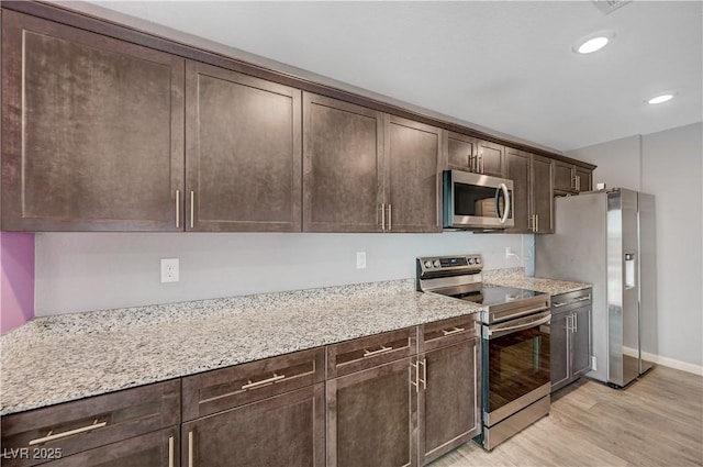 6940 Crescent Gold St, North Las Vegas, NV 89086 - kitchen featuring stainless steel appliances, dark brown cabinetry, light wood finished floors, recessed lighting, and light stone counters