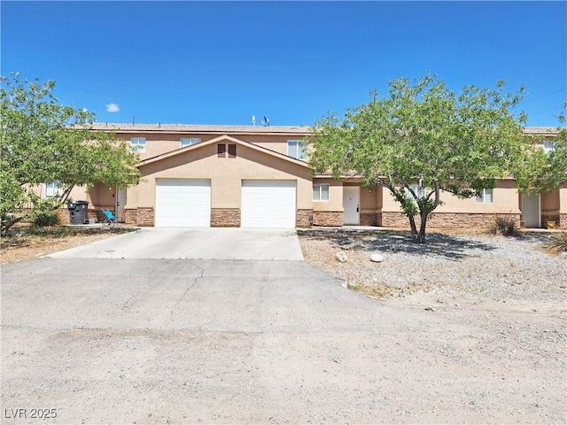 1951 Teepee Rd, Pahrump, NV 89048 - view of front of property featuring stone siding, stucco siding, an attached garage, and driveway