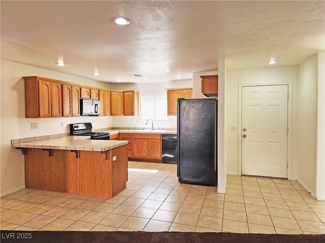 1951 Teepee Rd, Pahrump, NV 89048 - kitchen featuring black appliances, a peninsula, a sink, tile counters, and light tile patterned flooring