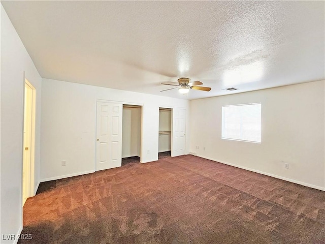 1951 Teepee Rd, Pahrump, NV 89048 - unfurnished bedroom with two closets, carpet flooring, baseboards, a ceiling fan, and a textured ceiling