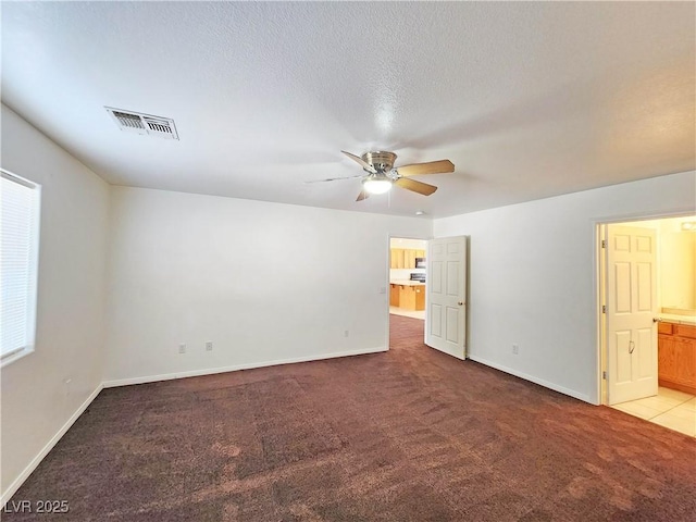 1951 Teepee Rd, Pahrump, NV 89048 - unfurnished bedroom with light colored carpet, baseboards, ensuite bath, and ceiling fan