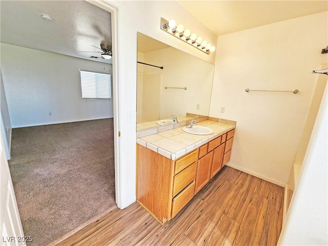 1951 Teepee Rd, Pahrump, NV 89048 - full bath featuring a ceiling fan, vanity, wood finished floors, baseboards, and bathtub / shower combination