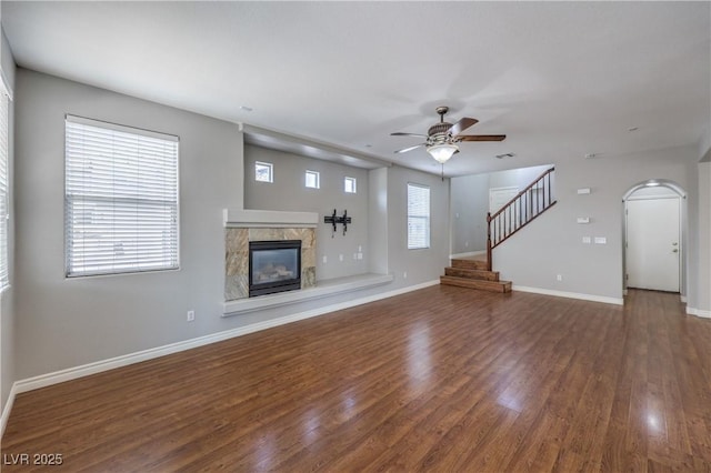 9005 Semillon St, Las Vegas, NV 89148 - unfurnished living room with a ceiling fan, wood finished floors, a glass covered fireplace, baseboards, and arched walkways