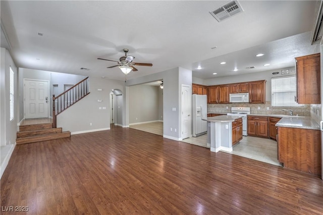 9005 Semillon St, Las Vegas, NV 89148 - kitchen with white appliances, a ceiling fan, a center island, open floor plan, and brown cabinetry