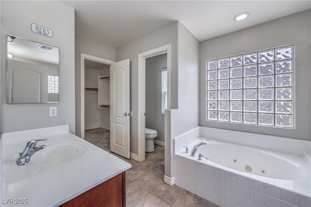 9005 Semillon St, Las Vegas, NV 89148 - bathroom featuring a whirlpool tub, toilet, vanity, tile patterned flooring, and baseboards