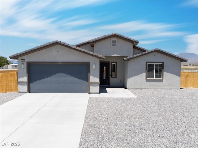 1500 E Laguna St, Pahrump, NV 89048 - view of front facade featuring stucco siding, an attached garage, driveway, and a tile roof