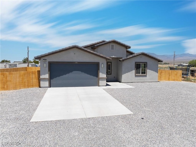 1500 E Laguna St, Pahrump, NV 89048 - view of front of house with stucco siding, driveway, an attached garage, a mountain view, and a tile roof