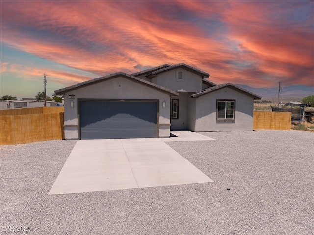 1500 E Laguna St, Pahrump, NV 89048 - view of front of home featuring stucco siding, concrete driveway, a garage, and a tiled roof