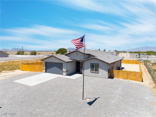 1500 E Laguna St, Pahrump, NV 89048 - view of front of house with driveway, a mountain view, a tiled roof, an attached garage, and stucco siding