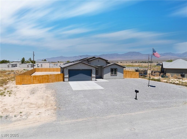 1500 E Laguna St, Pahrump, NV 89048 - view of front facade with a mountain view, a garage, and driveway
