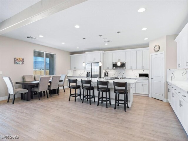 1500 E Laguna St, Pahrump, NV 89048 - kitchen featuring appliances with stainless steel finishes, tasteful backsplash, a kitchen breakfast bar, recessed lighting, and an island with sink